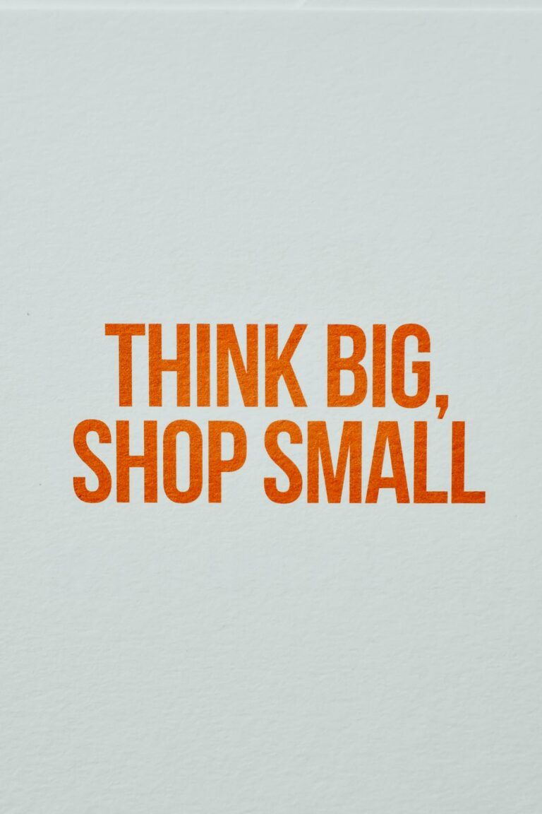 Minimalist orange text saying 'Think Big, Shop Small' on light background.